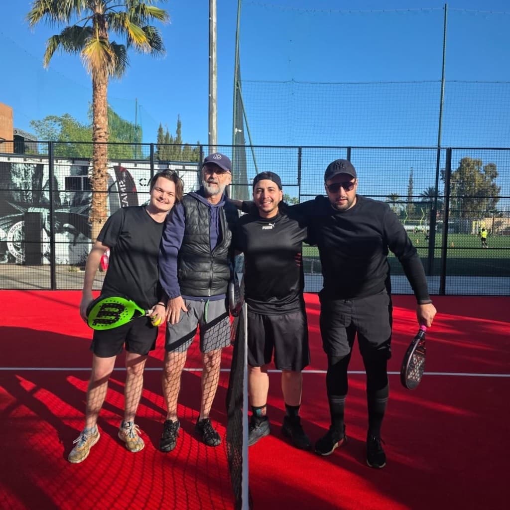 Équipe souriante sur un terrain rouge à KICK OFF Academy — Marrakech